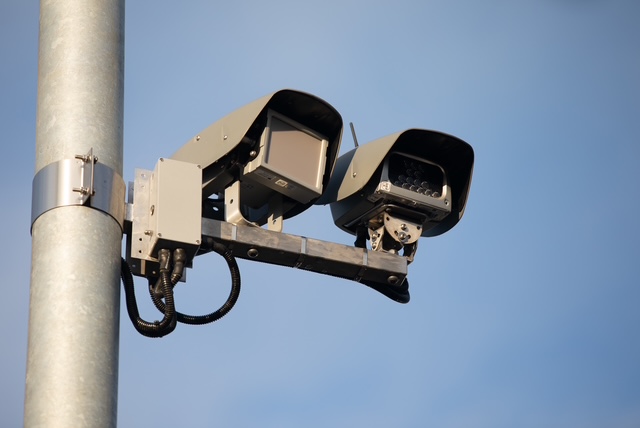 Cámaras avanzadas de monitoreo vial y lecturas inteligentes instaladas en un poste metálico, vistas en ángulo contrapicado contra un cielo despejado.